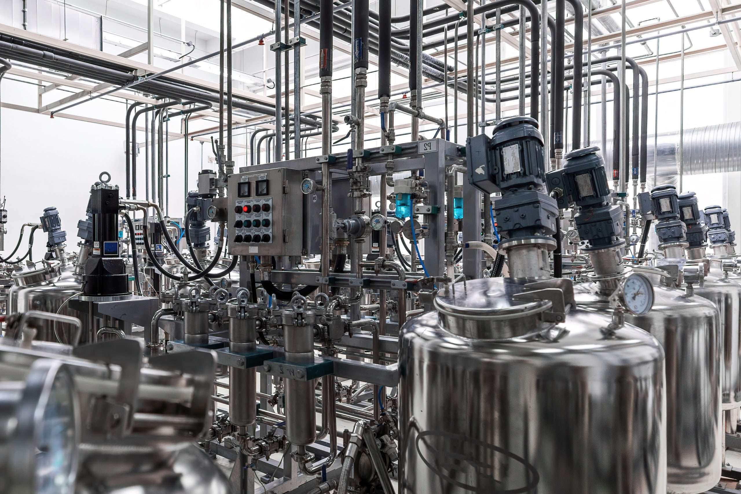 Photo of grey pipes and tanks. Chemistry and medicine production. Pharmaceutical factory. Interior of a high-tech factory, modern production